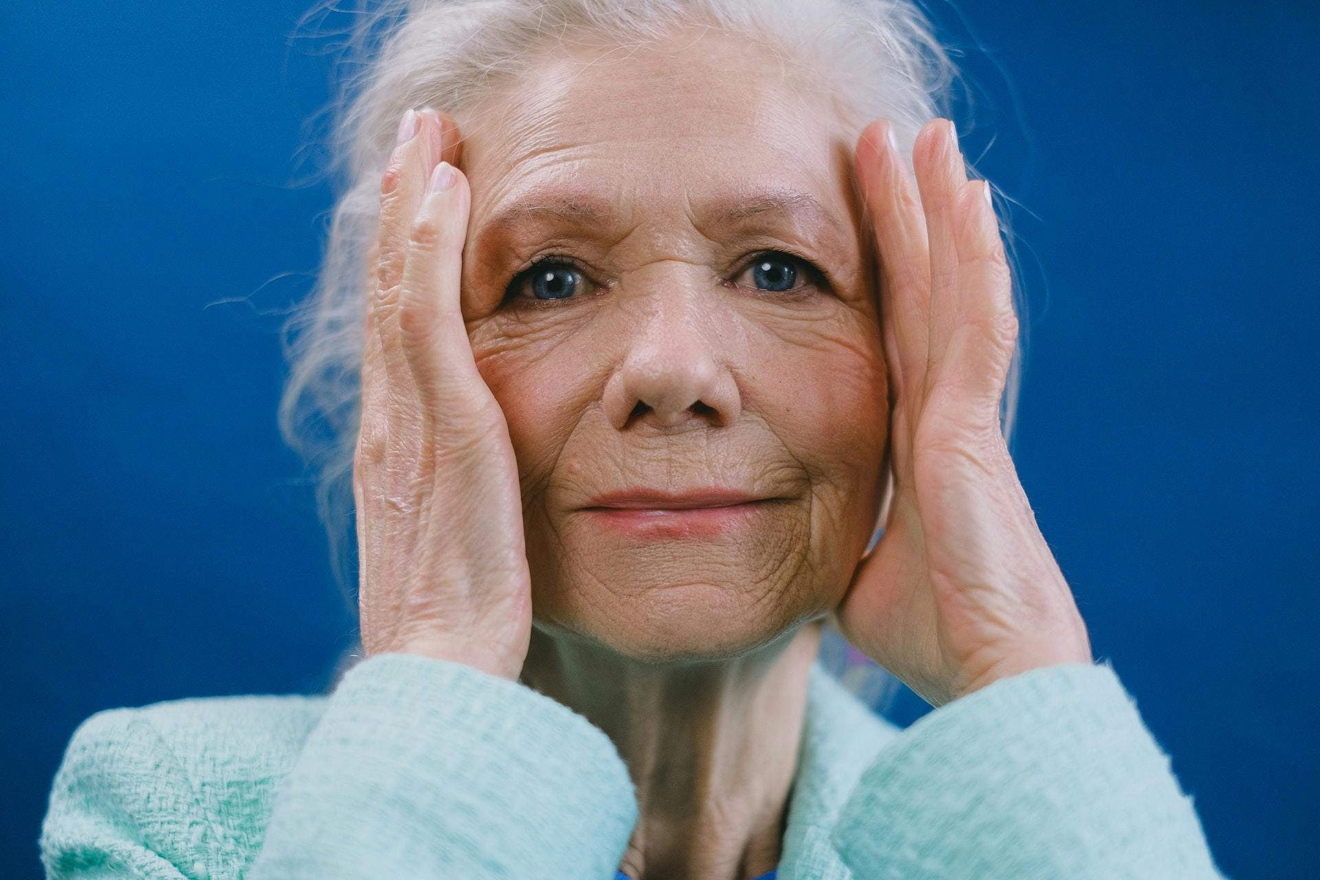 Old Woman Holding Head - Does Medicare Cover Migraines.jpg