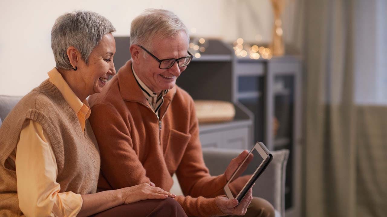 Finding Doctors Who Accept Medicare senior couple with tablet computer happy.jpg